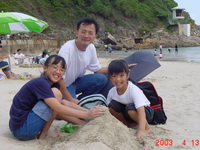 A person and two children playing with sand

Description automatically generated